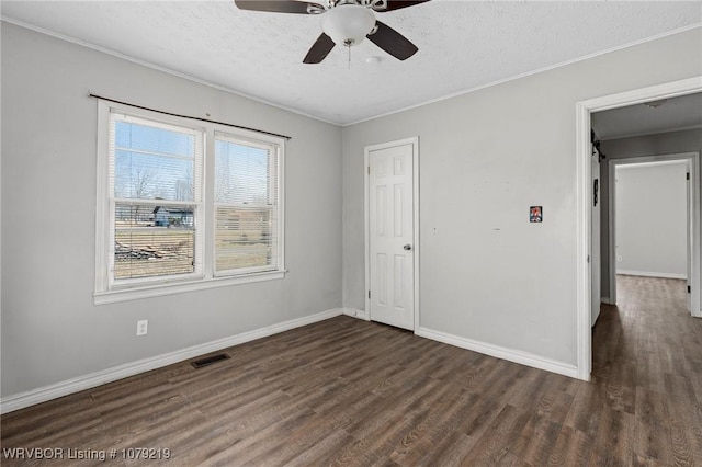 unfurnished bedroom with baseboards, a textured ceiling, visible vents, and dark wood-type flooring