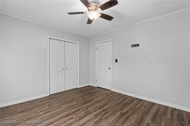 unfurnished bedroom featuring ceiling fan, a closet, wood finished floors, and baseboards