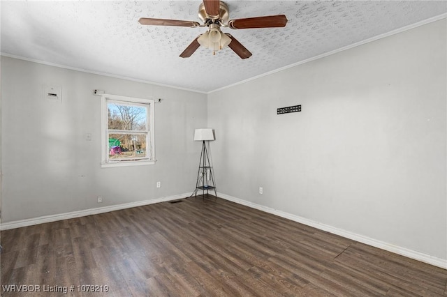 empty room with dark wood-style floors, a textured ceiling, baseboards, and crown molding