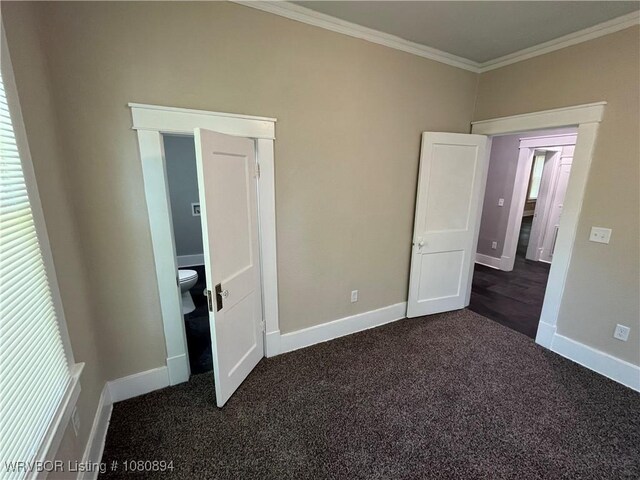 unfurnished bedroom featuring ornamental molding, dark carpet, and baseboards
