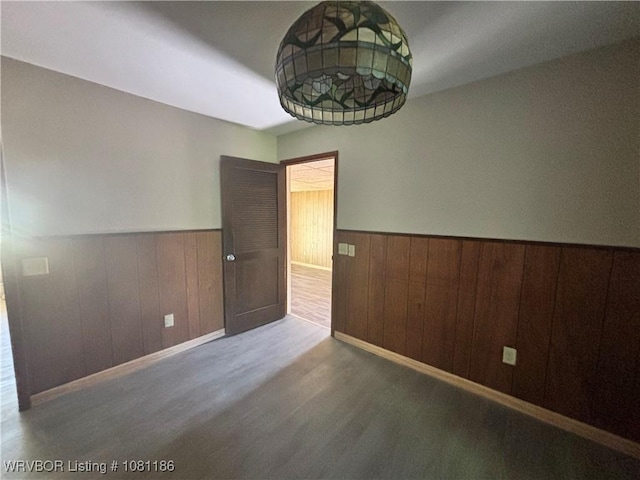 1117 W Creek Ave, Sallisaw, OK 74955 - spare room with wainscoting, wood finished floors, wood walls, and baseboards