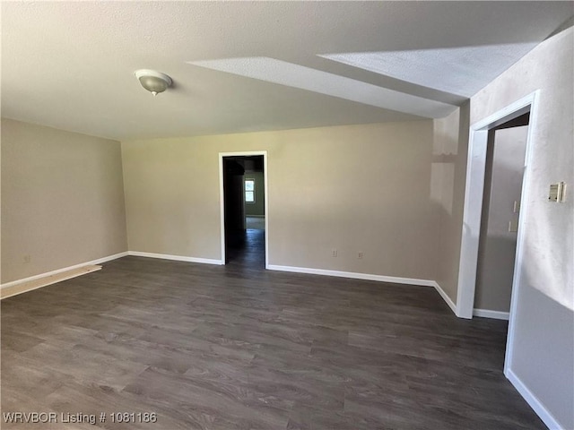 1117 W Creek Ave, Sallisaw, OK 74955 - unfurnished room featuring baseboards, dark wood-style floors, and a textured ceiling