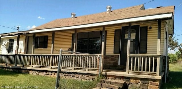 back of property featuring a porch and a yard