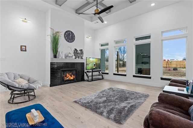 2205 Moody Rd, Barling, AR 72923 - living area with a warm lit fireplace, recessed lighting, ceiling fan, wood finished floors, and a towering ceiling