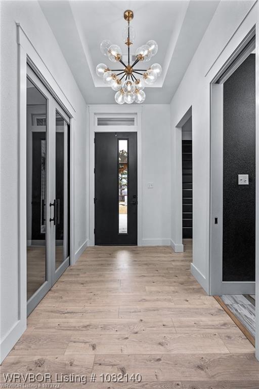 2205 Moody Rd, Barling, AR 72923 - entrance foyer with a chandelier, light wood-type flooring, and a tray ceiling