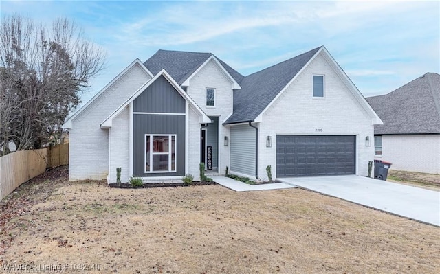 2205 Moody Rd, Barling, AR 72923 - view of front of home with brick siding, driveway, board and batten siding, and a shingled roof