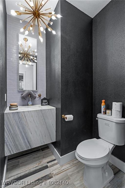2205 Moody Rd, Barling, AR 72923 - half bathroom with a chandelier, vanity, and a textured wall