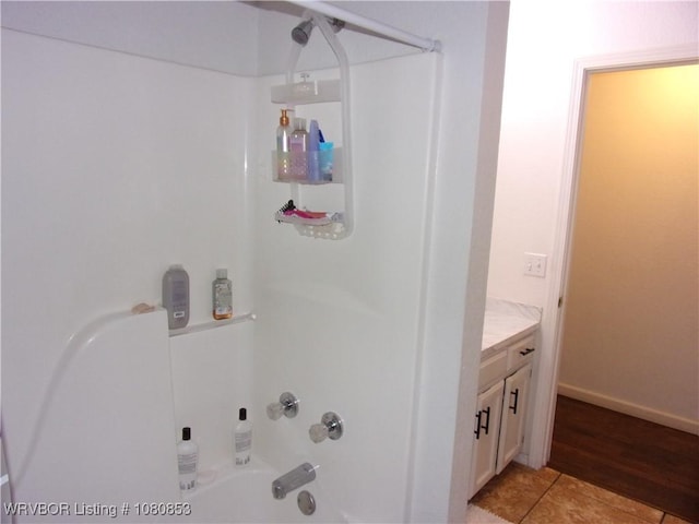 bathroom featuring shower / bath combination, vanity, baseboards, and wood finished floors