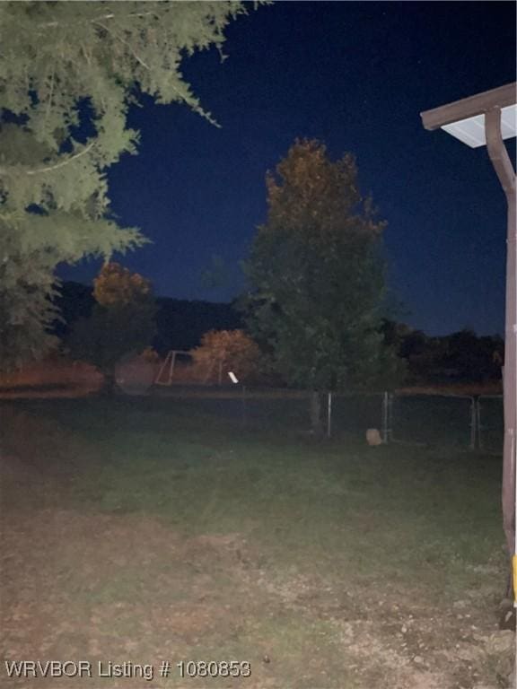 yard at twilight featuring fence