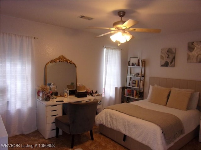 bedroom with light tile patterned floors, a ceiling fan, and visible vents