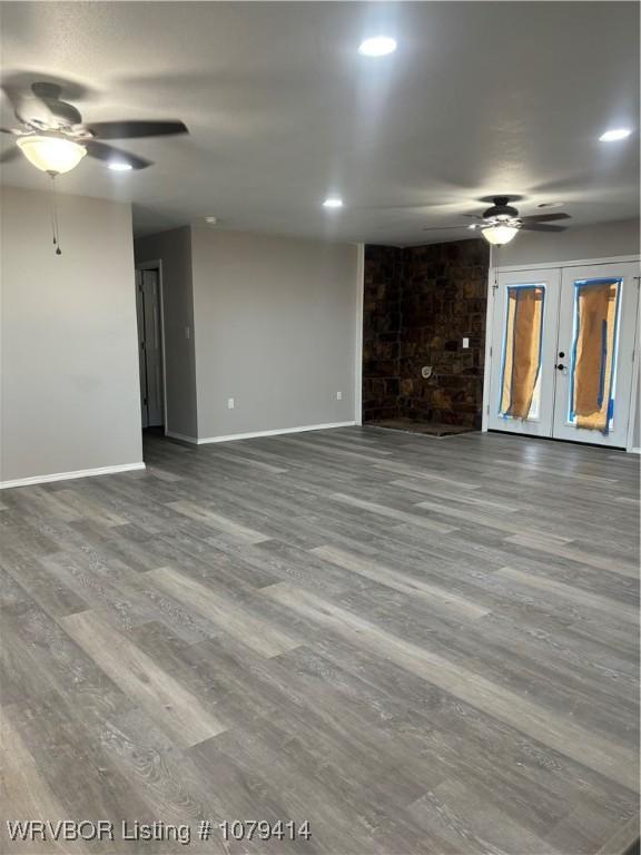 unfurnished living room with a ceiling fan, recessed lighting, baseboards, and wood finished floors