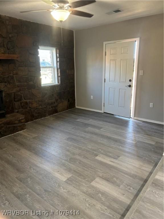 spare room with baseboards, ceiling fan, visible vents, and wood finished floors