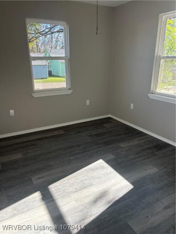 unfurnished room featuring baseboards and wood finished floors