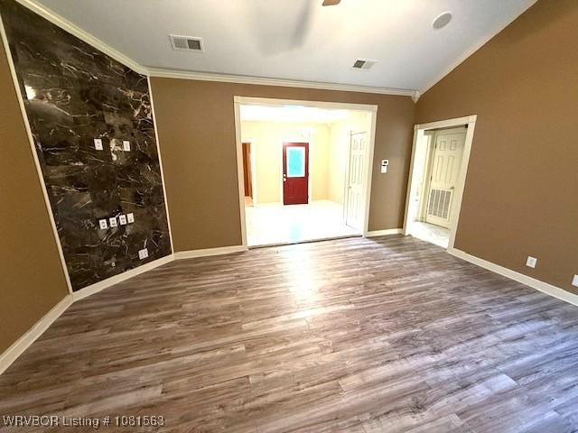 1434 W College St, Ozark, AR 72949 - empty room with crown molding, lofted ceiling, wood finished floors, ceiling fan, and baseboards