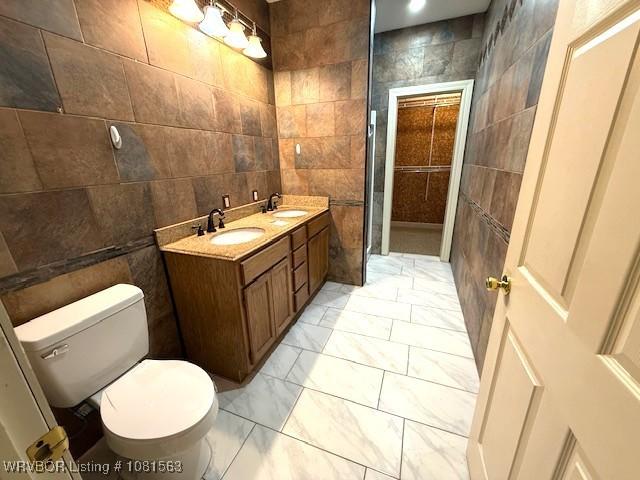 1434 W College St, Ozark, AR 72949 - full bath with tile walls, toilet, double vanity, and marble look tile flooring