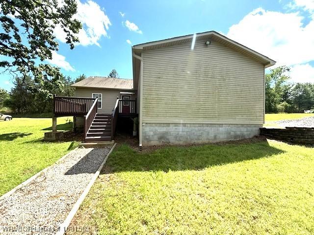 1434 W College St, Ozark, AR 72949 - view of home's exterior with a wooden deck, a lawn, and stairs