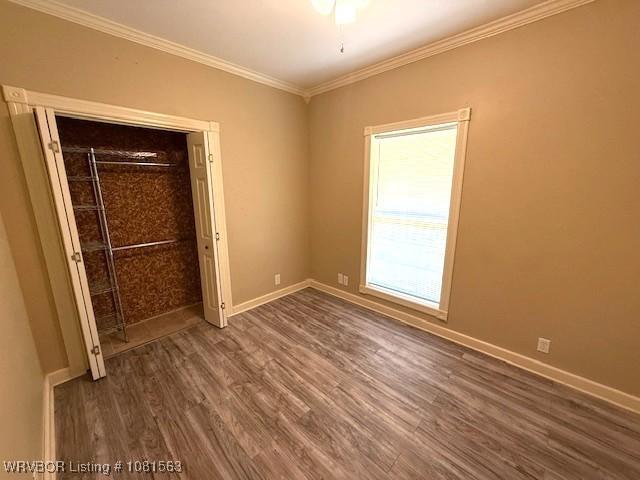 1434 W College St, Ozark, AR 72949 - unfurnished bedroom featuring wood finished floors, ornamental molding, baseboards, a ceiling fan, and a closet