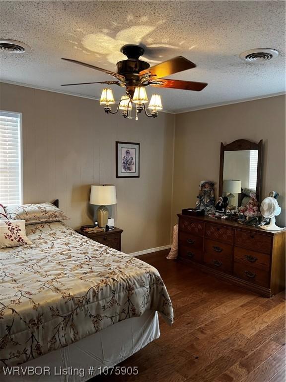 bedroom with a textured ceiling, dark hardwood / wood-style flooring, and ceiling fan