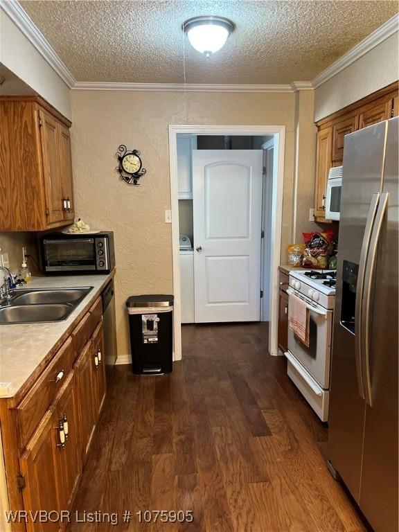 kitchen with dark hardwood / wood-style floors, sink, stainless steel appliances, and a textured ceiling