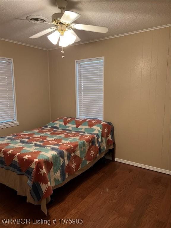 bedroom with dark hardwood / wood-style flooring, a textured ceiling, ceiling fan, and ornamental molding