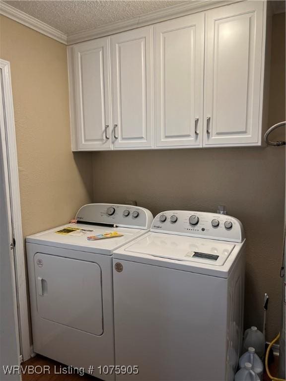 washroom featuring washing machine and clothes dryer, crown molding, cabinets, and a textured ceiling