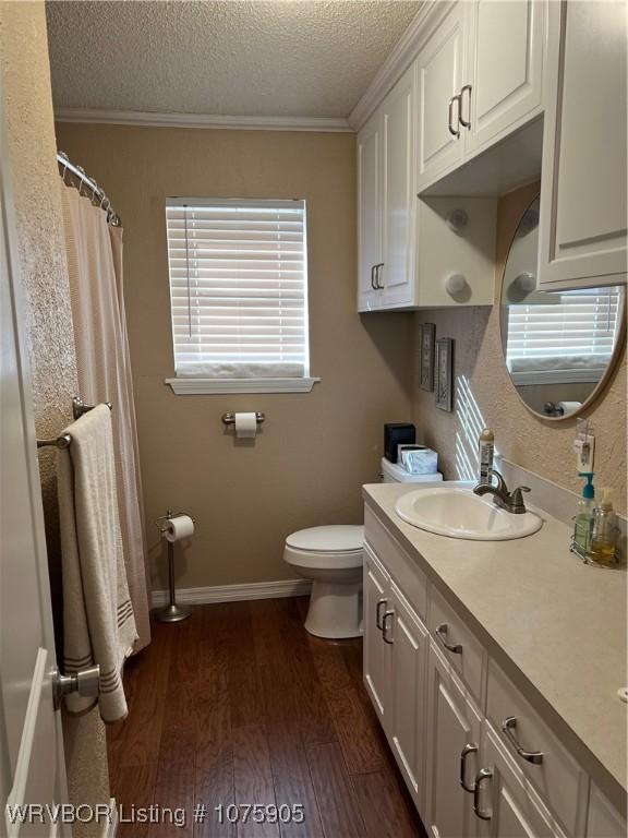 bathroom featuring vanity, crown molding, toilet, a textured ceiling, and wood-type flooring