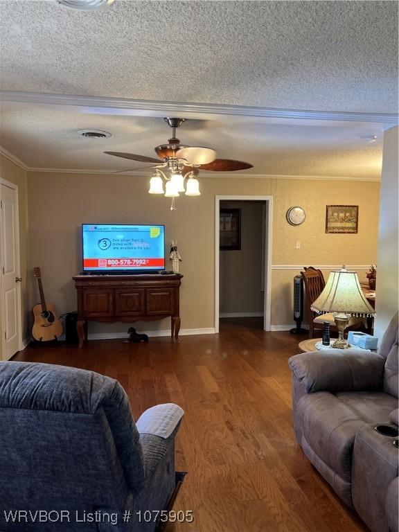 living room featuring ceiling fan, ornamental molding, a textured ceiling, and hardwood / wood-style flooring