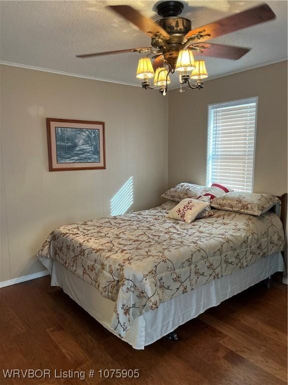 bedroom featuring ornamental molding, a textured ceiling, ceiling fan, and dark wood-type flooring