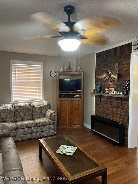 living room with hardwood / wood-style floors, ceiling fan, and a textured ceiling