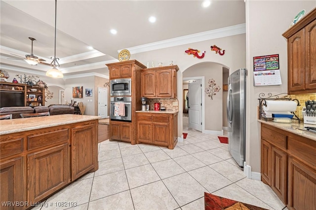 479872 E 1080th Rd, Muldrow, OK 74948 - kitchen featuring stainless steel appliances, arched walkways, backsplash, ornamental molding, and brown cabinetry