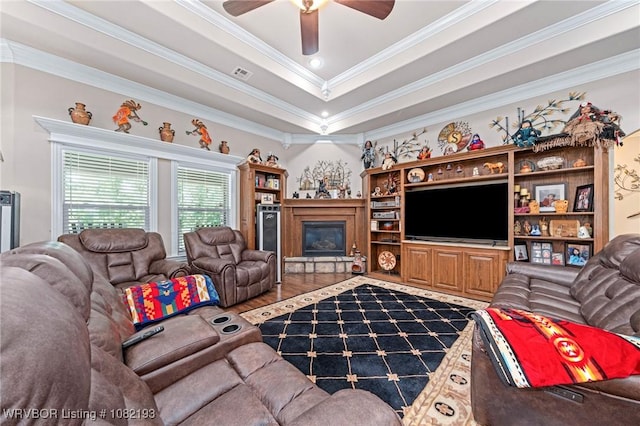 479872 E 1080th Rd, Muldrow, OK 74948 - living room with ornamental molding, wood finished floors, a ceiling fan, a glass covered fireplace, and a raised ceiling