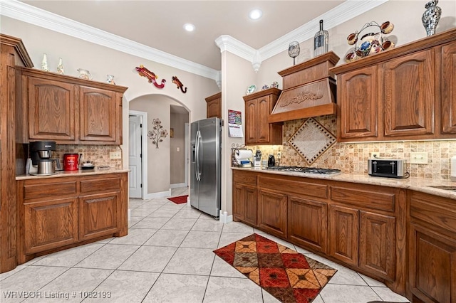 479872 E 1080th Rd, Muldrow, OK 74948 - kitchen with appliances with stainless steel finishes, tasteful backsplash, arched walkways, ornamental molding, and brown cabinets