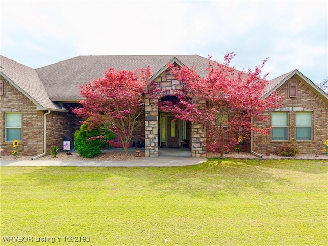 479872 E 1080th Rd, Muldrow, OK 74948 - view of front of home with a front yard, brick siding, roof with shingles, and stone siding