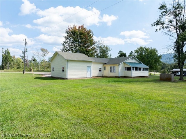 rear view of property featuring a lawn