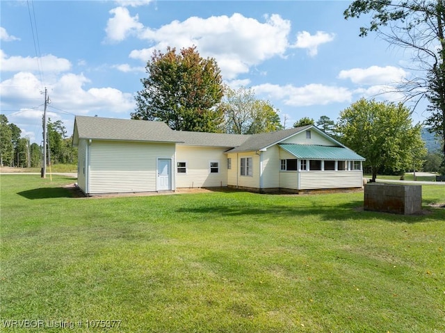 rear view of property with a yard