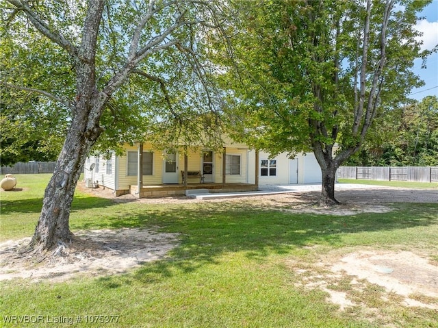 view of property hidden behind natural elements featuring a porch and a front lawn