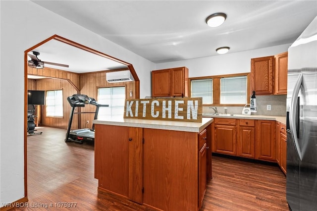 kitchen featuring stainless steel fridge with ice dispenser, ceiling fan, dark hardwood / wood-style floors, and a wall mounted air conditioner