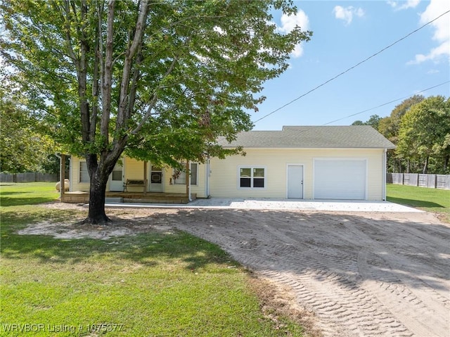 view of front of property featuring covered porch, a garage, and a front lawn