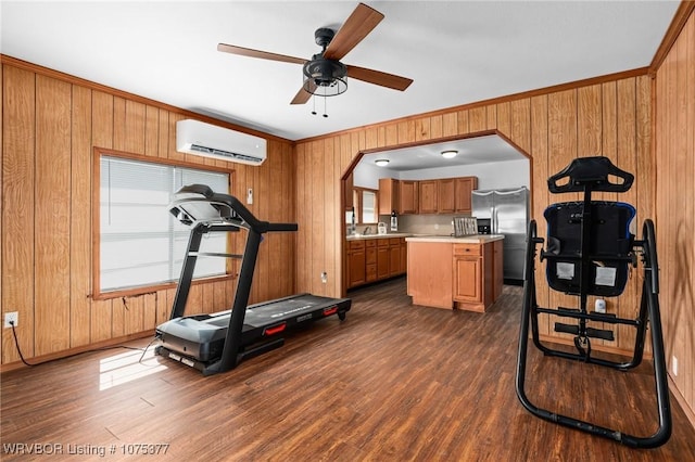 exercise area with ceiling fan, dark hardwood / wood-style floors, a wall mounted AC, crown molding, and wooden walls