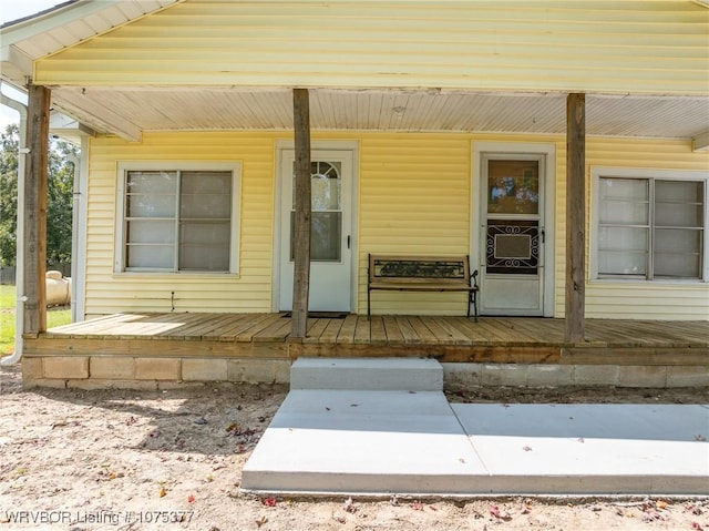 entrance to property with a porch and cooling unit