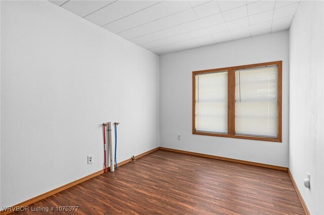 unfurnished room with dark hardwood / wood-style flooring