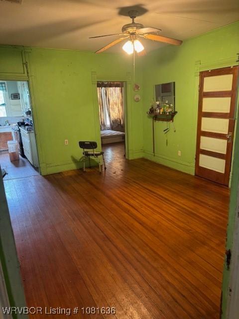 24 S 3rd St, Paris, AR 72855 - unfurnished living room with wood finished floors and a ceiling fan
