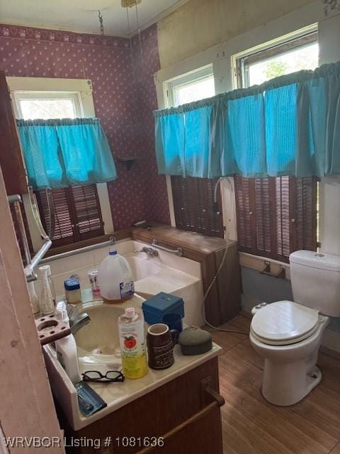 24 S 3rd St, Paris, AR 72855 - bathroom with healthy amount of natural light, wallpapered walls, and wood finished floors