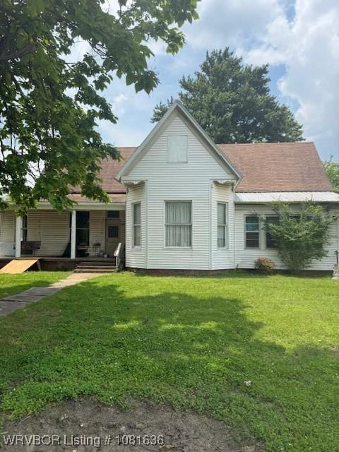 24 S 3rd St, Paris, AR 72855 - back of house with a lawn and covered porch