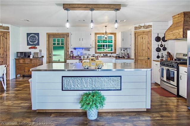 kitchen with stainless steel range with gas cooktop, white cabinetry, sink, and decorative light fixtures