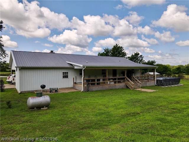 back of property with a yard and a deck