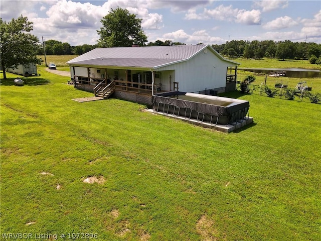 back of property with a yard and a water view