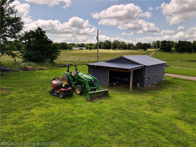 view of outbuilding featuring a lawn and a rural view