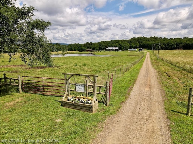 view of home's community featuring a rural view, a water view, and a lawn