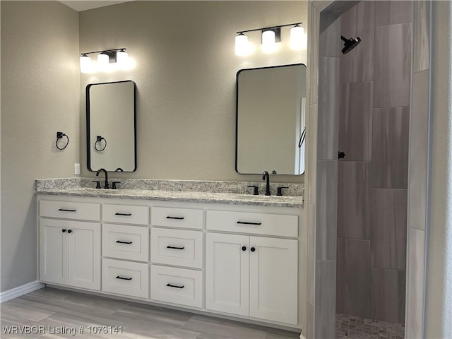 bathroom with hardwood / wood-style flooring, vanity, and a shower